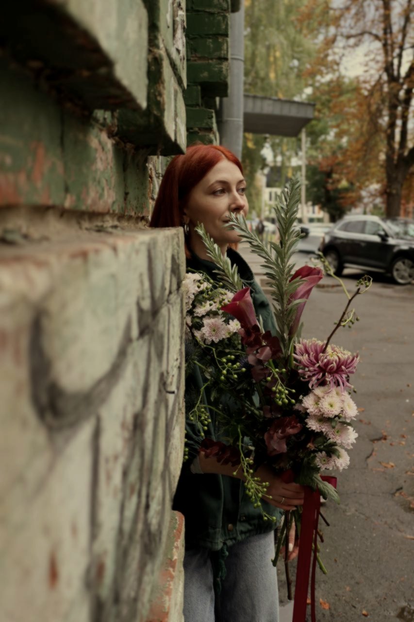 Flowers first, then a face, against a brick corner that does the cropping