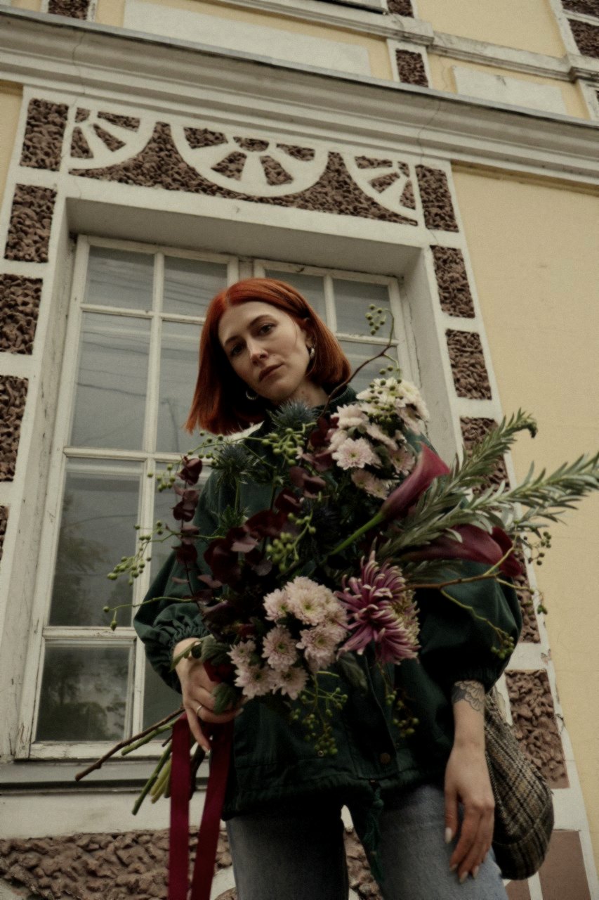 A bouquet and a face last, inside a worn fanlight window